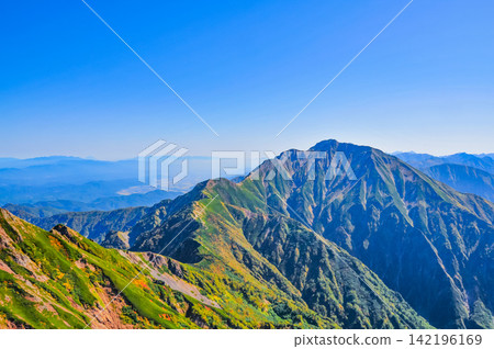 On a clear autumn morning, the mountain range towards Mt. Goryu can be seen from the hiking trail of Mt. Karamatsu under a clear blue sky. On a clear autumn morning, the mountain range towards Mt. Goryu can be seen from the hiking trail of Mt. Karamatsu under a clear blue sky. 142196169