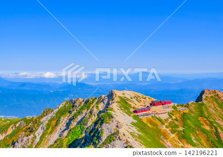 在一個晴朗的秋日早晨，從唐松山頂眺望唐松山頂小屋，遠處可以看到淺山方向的山脈。 142196221