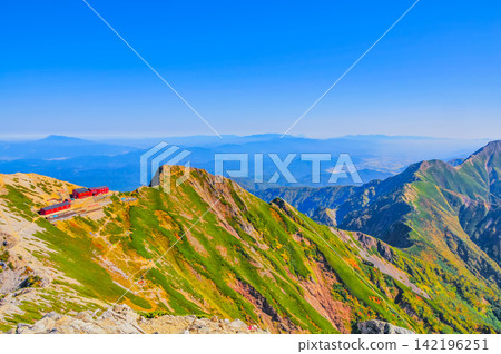 在一個晴朗的秋日早晨,從唐松山頂眺望唐松山頂小屋,遠處可以看到八嶽山脈和富士山。 在一個晴朗的秋日早晨,從唐松山頂眺望唐松山頂小屋,遠處可以看到八嶽山脈和富士山。 142196251
