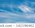 Thin clouds drift across the blue summer sky. 142196462