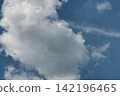 Large white clouds spread across the summer sky. 142196465