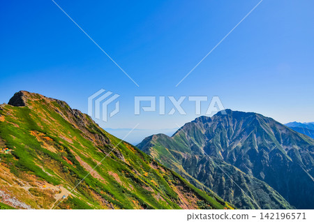 On a clear autumn morning, the mountain range towards Mt. Goryu can be seen from the hiking trail of Mt. Karamatsu under a clear blue sky. On a clear autumn morning, the mountain range towards Mt. Goryu can be seen from the hiking trail of Mt. Karamatsu under a clear blue sky. 142196571