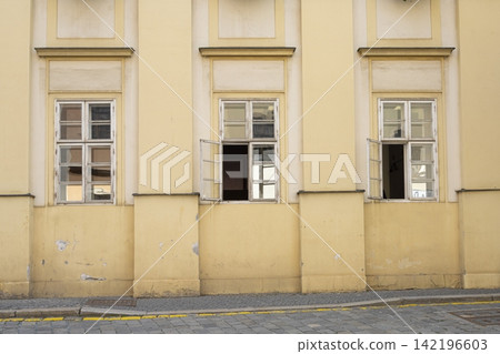 Three windows on a pale yellow building facade Three windows on a pale yellow building facade 142196603