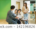 Four young Japanese men and women having a meeting in the office. Four young Japanese men and women having a meeting in the office. 142196826