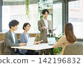 Four young Japanese men and women giving a presentation in the office. Four young Japanese men and women giving a presentation in the office. 142196832