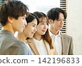 Close-ups of the faces of a young Japanese man and woman standing side by side in an office. Close-ups of the faces of a young Japanese man and woman standing side by side in an office. 142196833