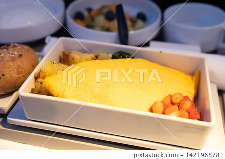 在一家歐洲航空公司的國際航班商務艙早餐中，享用了一份美味的起司煎蛋捲。 142196878