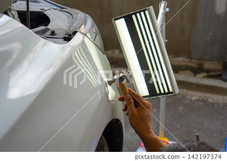 Removing dents on the car. PDR technology. Car body repair without painting. 142197374
