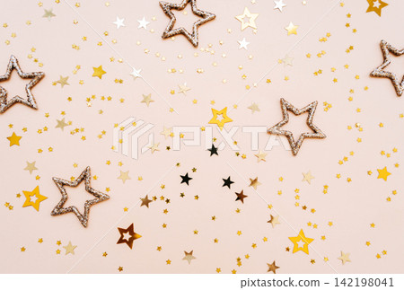 Golden and glittering stars on beige background Golden and glittering stars on beige background 142198041