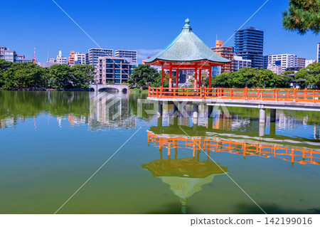 Famous hexagonal red pavilion of Ohori lake park with Fukuoka city view Famous hexagonal red pavilion of Ohori lake park with Fukuoka city view 142199016