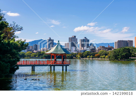 Couple at iconic hexagonal red pavilion from Ohori lake, Fukuoka Couple at iconic hexagonal red pavilion from Ohori lake, Fukuoka 142199018