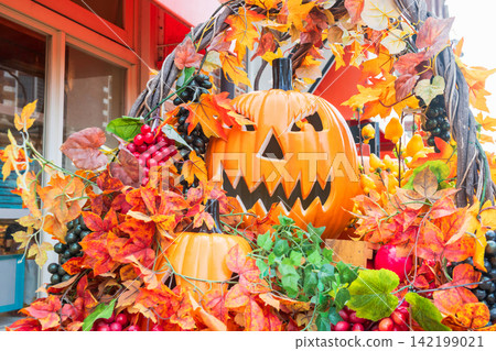 Smiling Jack O lantern pumpkin with grape and maple tree, hallloween 142199021