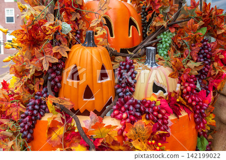 Smiling Jack O lantern pumpkin with grape fruits for hallloween decoration Smiling Jack O lantern pumpkin with grape fruits for hallloween decoration 142199022