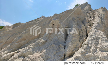 Weathered limestone rock formations with rugged textures beneath a bright blue sky, highlighting natural erosion, geological patterns and the beauty of an untouched outdoor landscape. Weathered limestone rock formations with rugged textures beneath a bright blue sky, highlighting natural erosion, geological patterns and the beauty of an untouched outdoor landscape. 142199280