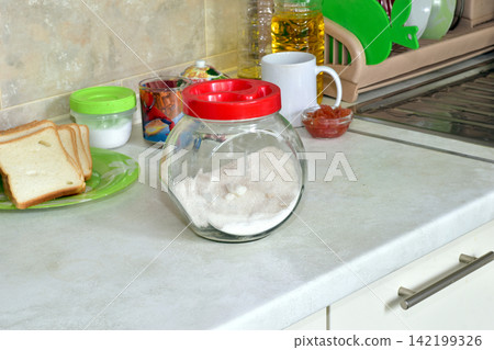 There are objects on the kitchen table. There are objects on the kitchen table. 142199326
