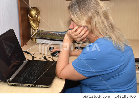 A woman is working on a laptop. A woman is working on a laptop. 142199460