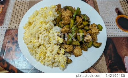 Homemade egg fried rice served with diced chicken and zucchini on a plate Homemade egg fried rice served with diced chicken and zucchini on a plate 142199480