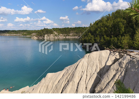 Turquoise lake surrounded by lush green forest and white rocky cliffs under a bright summer sky, creating a peaceful scenic landscape ideal for travel, vacation, and outdoor adventure. Turquoise lake surrounded by lush green forest and white rocky cliffs under a bright summer sky, creating a peaceful scenic landscape ideal for travel, vacation, and outdoor adventure. 142199486