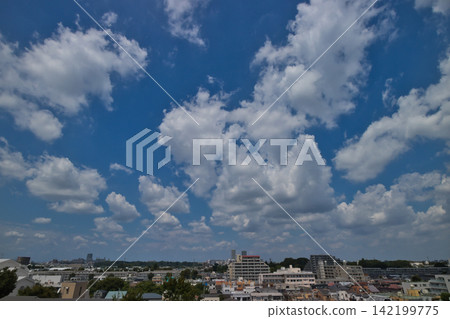 Blue sky and white clouds; a refreshing blue sky and a residential area. Blue sky and white clouds; a refreshing blue sky and a residential area. 142199775