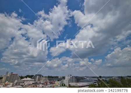 Blue sky and white clouds; a refreshing blue sky and a residential area. Blue sky and white clouds; a refreshing blue sky and a residential area. 142199776