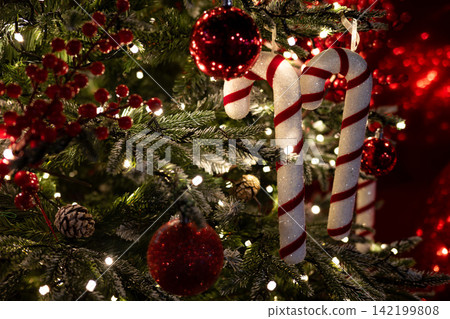 Close-Up of Decorated Christmas Tree with Twinkling Lights and Festive Ornaments and candy canes. Close-Up of Decorated Christmas Tree with Twinkling Lights and Festive Ornaments and candy canes. 142199808