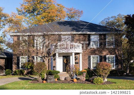 Private house in suburban autumn area. Suburban house architecture. Suburb exterior with Halloween decoration. Suburban neighborhood. Private family home architecture. Autumn season Private house in suburban autumn area. Suburban house architecture. Suburb exterior with Halloween decoration. Suburban neighborhood. Private family home architecture. Autumn season 142199821