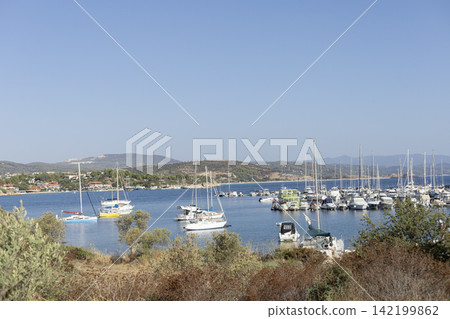 Sailboats and motorboats anchored in a Mediterranean coastal bay 142199862