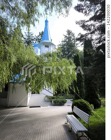 White-stone chapel with a blue dome in a green park White-stone chapel with a blue dome in a green park 142200030