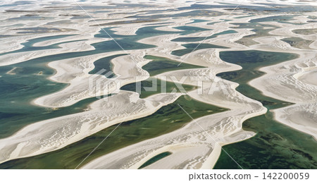 Aerial view of Lençóis Maranhenses, featuring white sand dunes with intricate patterns of wet sand and a deep green lagoon. Aerial view of Lençóis Maranhenses, featuring white sand dunes with intricate patterns of wet sand and a deep green lagoon. 142200059