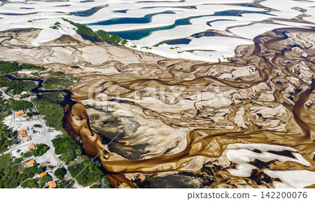 從空中俯瞰,貝瑟尼附近白色沙丘間蜿蜒著棕色的水道和居民點。 從空中俯瞰,貝瑟尼附近白色沙丘間蜿蜒著棕色的水道和居民點。 142200076