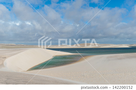 The turquoise lagoon swaying in the wind and the white sand dunes of Lençóis Maranhenses The turquoise lagoon swaying in the wind and the white sand dunes of Lençóis Maranhenses 142200152