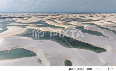 Aerial view of Lençóis Maranhenses, where white sand dunes are surrounded by blue-green lagoons. Aerial view of Lençóis Maranhenses, where white sand dunes are surrounded by blue-green lagoons. 142200177
