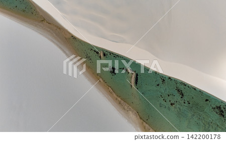 從空中俯瞰,綠色的潟湖沿著倫索伊斯馬拉尼昂塞斯的白色沙丘綿延。 從空中俯瞰,綠色的潟湖沿著倫索伊斯馬拉尼昂塞斯的白色沙丘綿延。 142200178