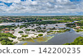 Aerial view of the settlement overlooking the wetlands and sandbars of the Grande River and white sand dunes, Santo Amaro 142200235
