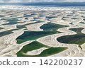 An aerial view of cloud-covered white sand dunes and a vast verdigris lagoon, Lençóis Maranhenses. 142200237