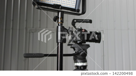 Digital Camera On A Tripod Behind Lighting Panel For Studio Shooting 142200498