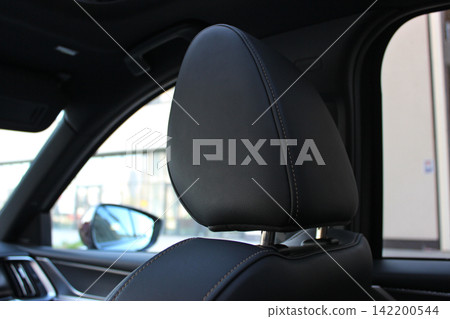 The upper part of the car seat with an anatomical headrest is covered with expensive leather 142200544