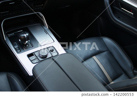 Aluminum covering of the central console with control units of the transmission and driving modes in a business class car interior with leather upholstery 142200553