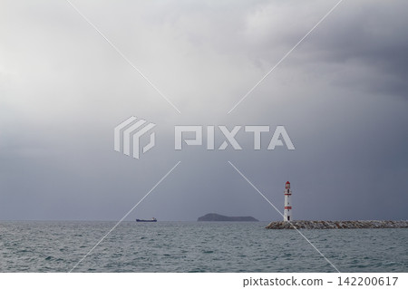 Seascape at sunshine. Lighthouse and sailings on the coast. Seaside town of Turgutreis and spectacular sunshine Seascape at sunshine. Lighthouse and sailings on the coast. Seaside town of Turgutreis and spectacular sunshine 142200617