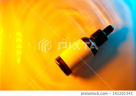 Cosmetic serum dropping into water with ripple effects Cosmetic serum dropping into water with ripple effects 142201341