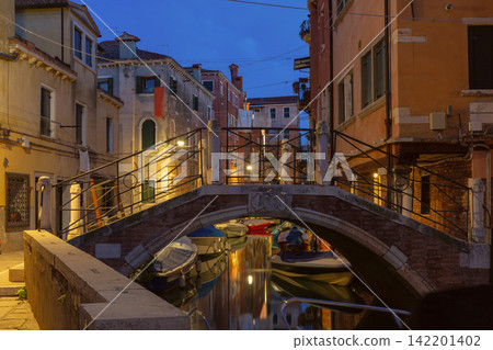 Venetian Canal with Bridges and Reflections Before Sunrise in Venice, Italy Venetian Canal with Bridges and Reflections Before Sunrise in Venice, Italy 142201402