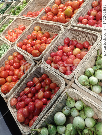 Fresh tomato and green eggplant display at market Fresh tomato and green eggplant display at market 142201683