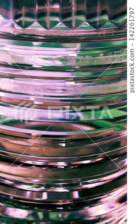 Abstract ribbed glass texture with pink and emerald reflections close up Abstract ribbed glass texture with pink and emerald reflections close up 142201797