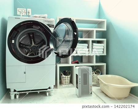A bright laundry room with a drum-type washing machine. A bright laundry room with a drum-type washing machine. 142202174