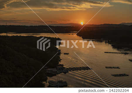 夕陽西下，群山環繞，金色的光芒灑在三重縣志摩市的阿厝灣上。 142202204
