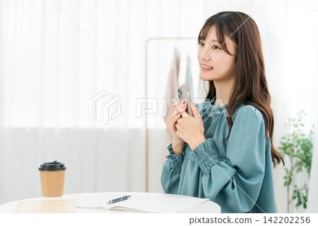 Young Asian businesswoman using smartphone at work in office Young Asian businesswoman using smartphone at work in office 142202256