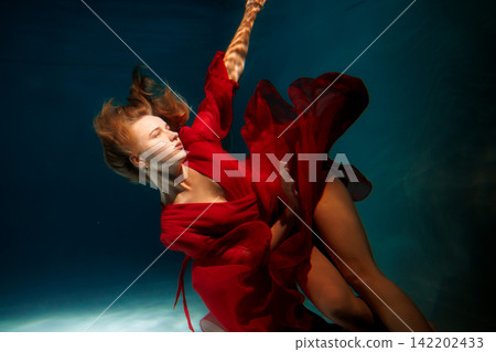 Caucasian lady in crimson fabric looking into distance thoughtfully Caucasian lady in crimson fabric looking into distance thoughtfully 142202433