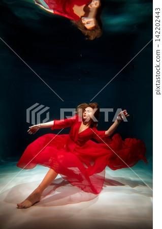 Woman adorned in scarlet attire peacefully drifting through air Woman adorned in scarlet attire peacefully drifting through air 142202443