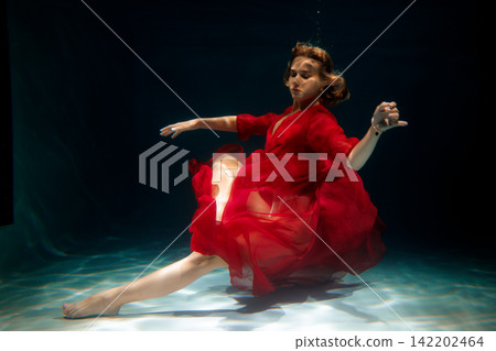 Quiet marine environment featuring woman dressed in scarlet with soft waves Quiet marine environment featuring woman dressed in scarlet with soft waves 142202464
