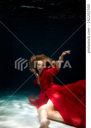 Vibrant underwater ballet with lively movements and colorful lighting 142202500